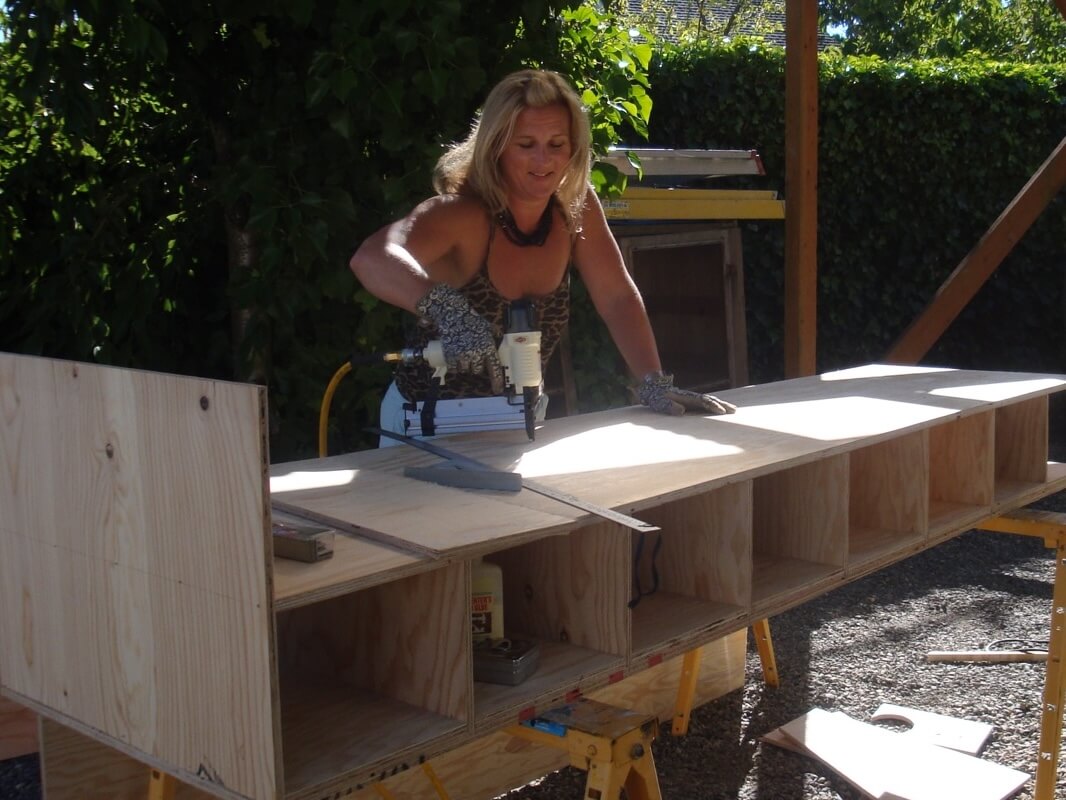 Jennifer Ryan at work, building a custom storage unit, demonstrating her hands-on approach to design
